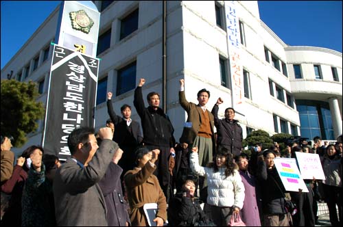 경남지역 시민사회단체 대표들이 경남도의회 간판에 '근조 경상남도 한나라당의회'라 붙여놓고 구호를 외치고 있다. 